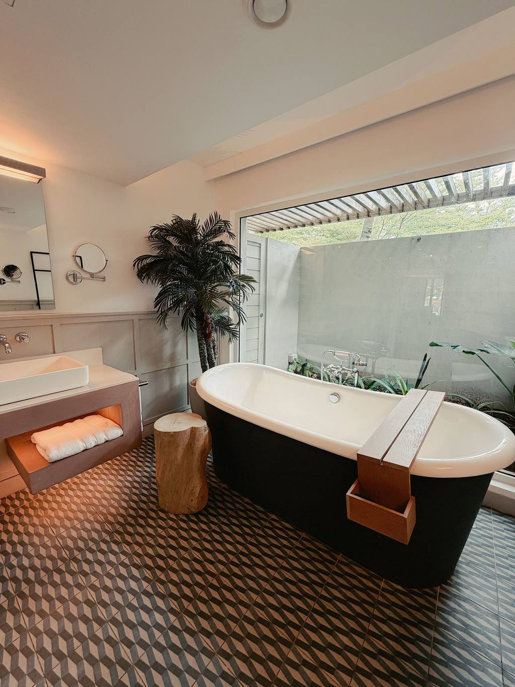 Modern bathroom with freestanding tub, large window and geometric tiles